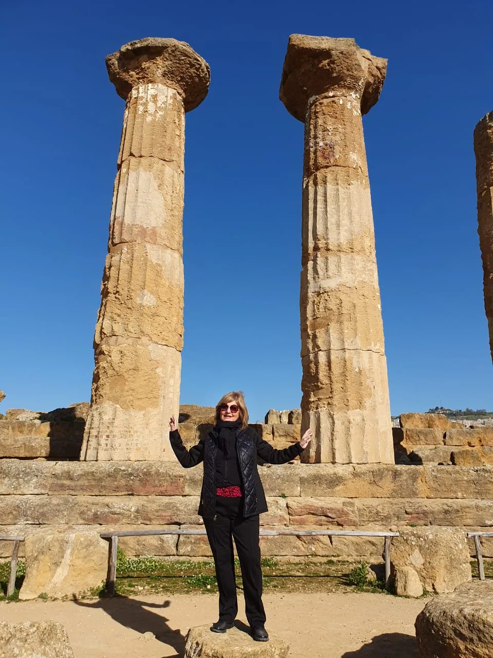 Responsable de Manes Turismo frente a columnas de un sitio arqueológico